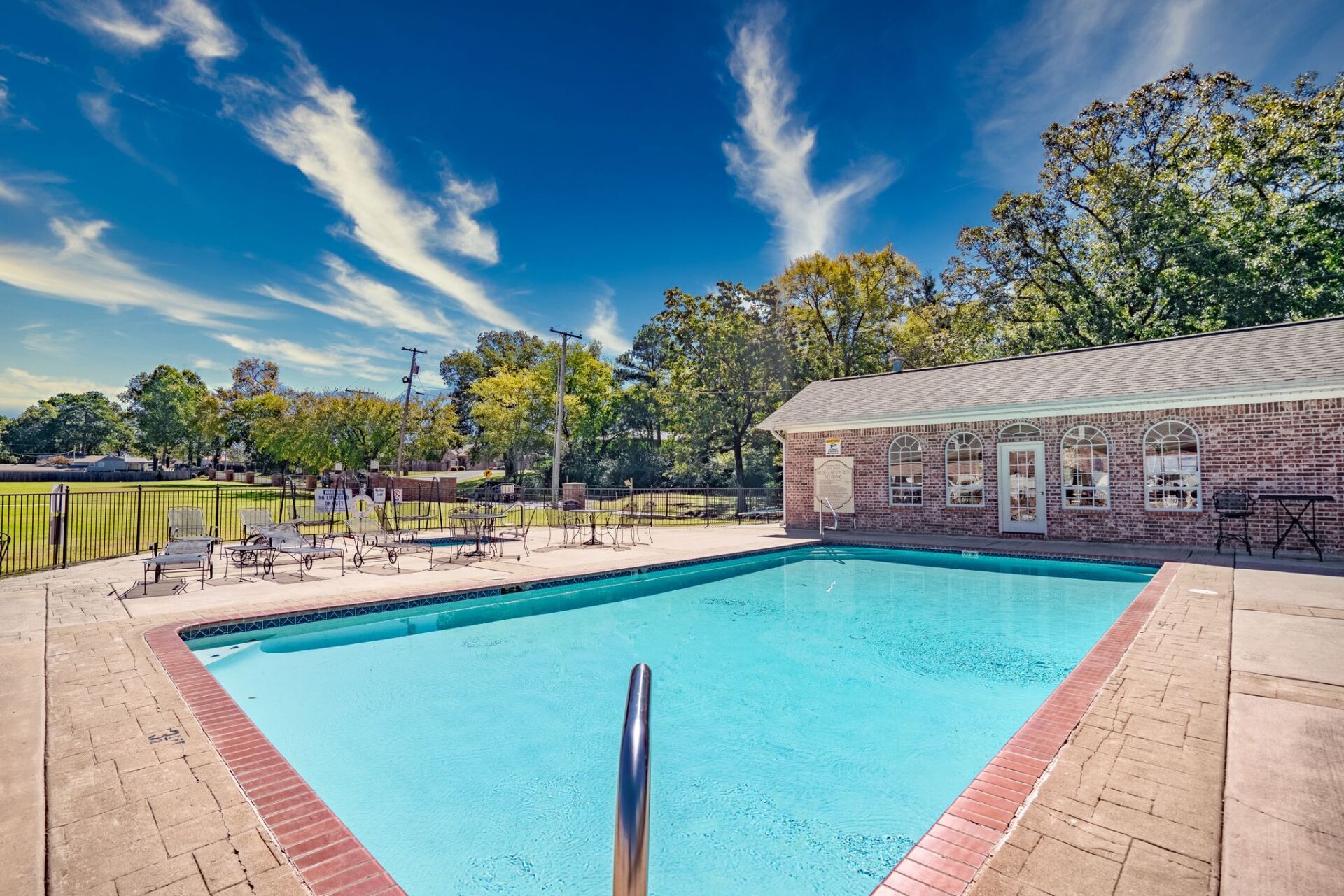 A large swimming pool with a brick building in the background
