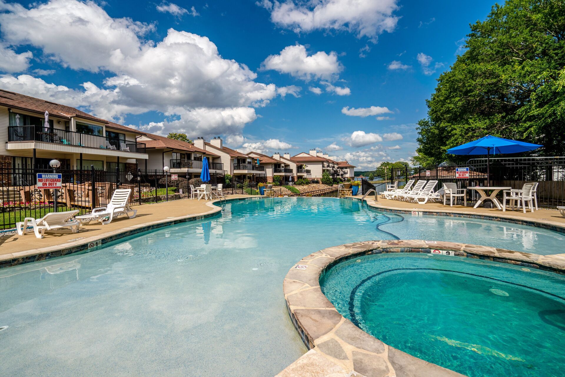 There is a large swimming pool and a hot tub in the middle of the pool.