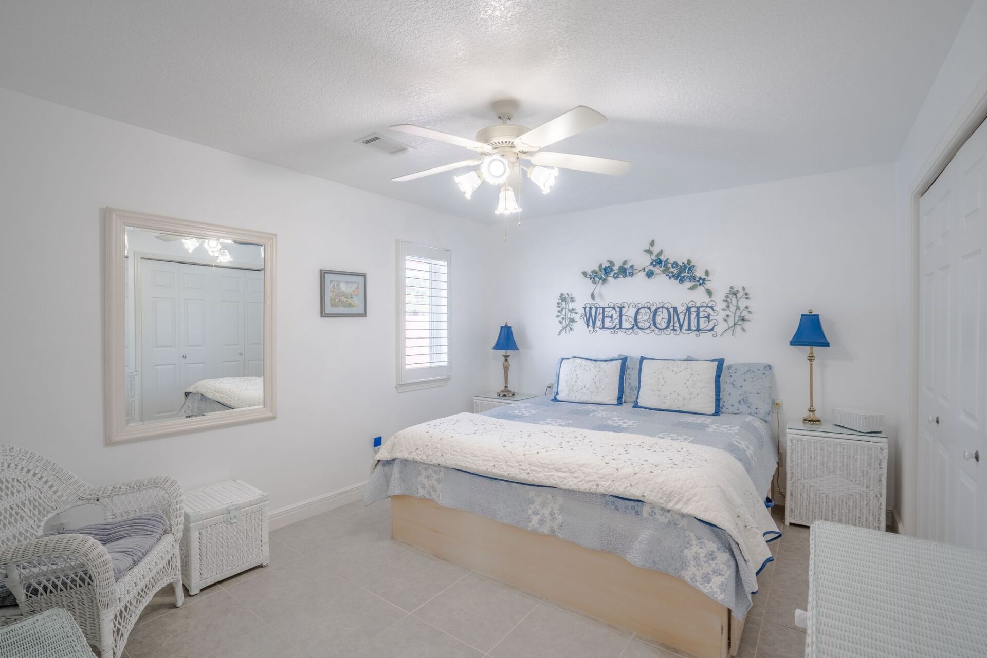 A bedroom with a king size bed and a ceiling fan.