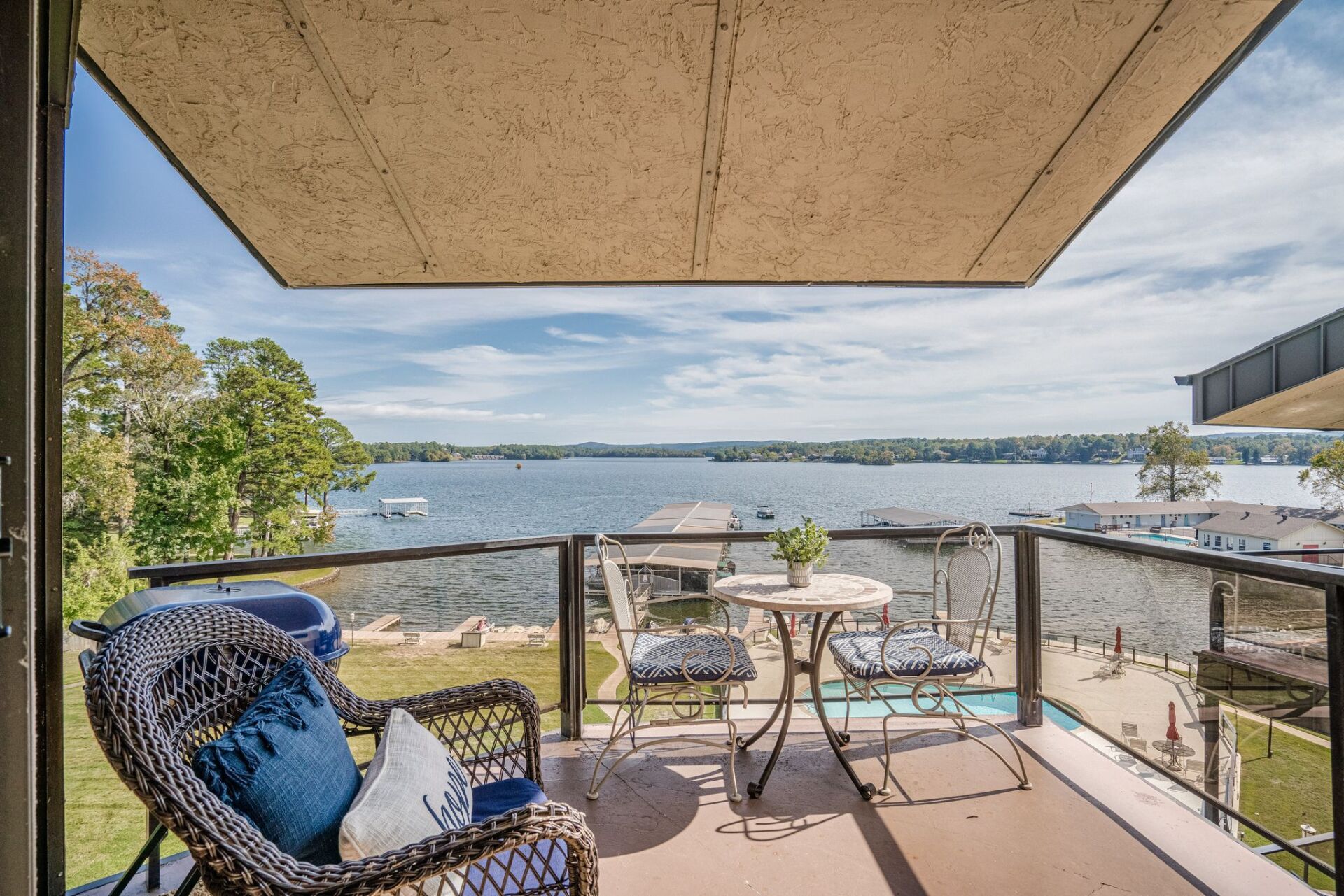 A balcony with a table and chairs overlooking a lake.