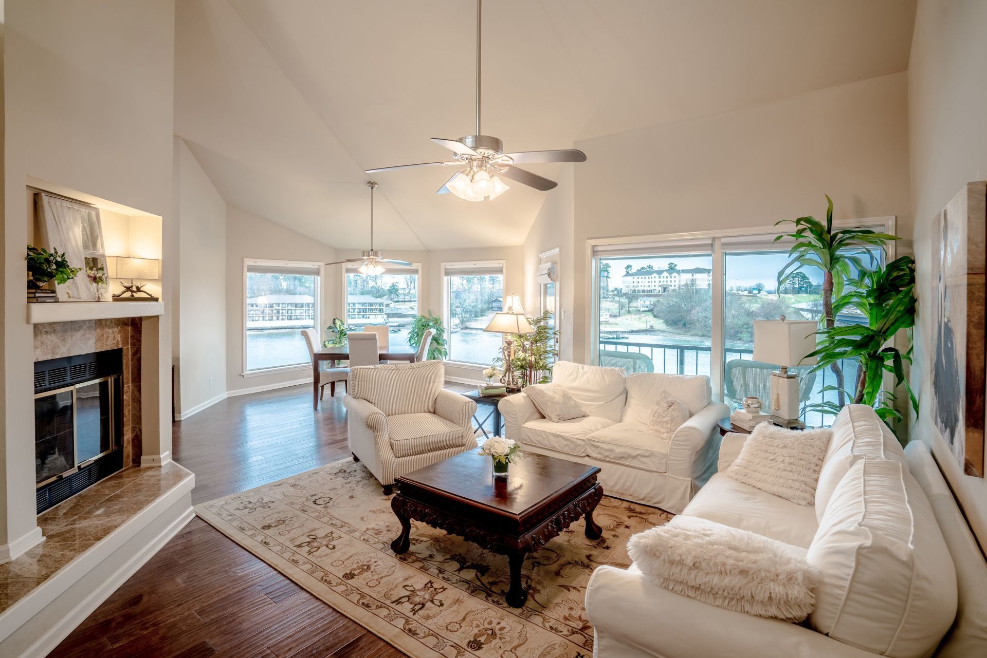 A living room with white furniture and a fireplace