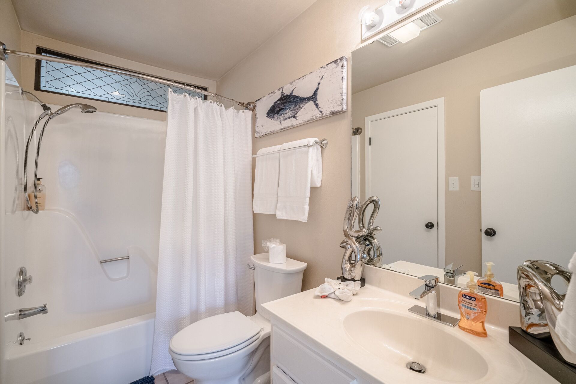 A bathroom with a toilet , sink , tub and shower.