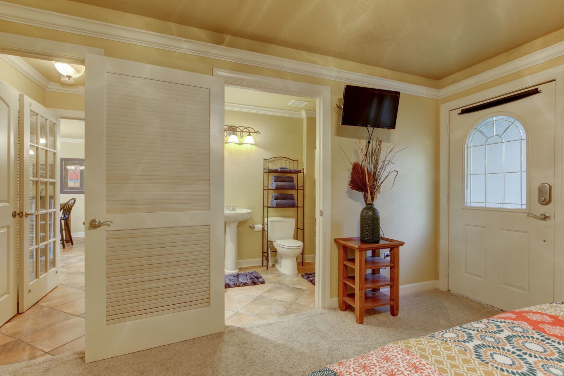 A bedroom with a bed , toilet , sink and television.