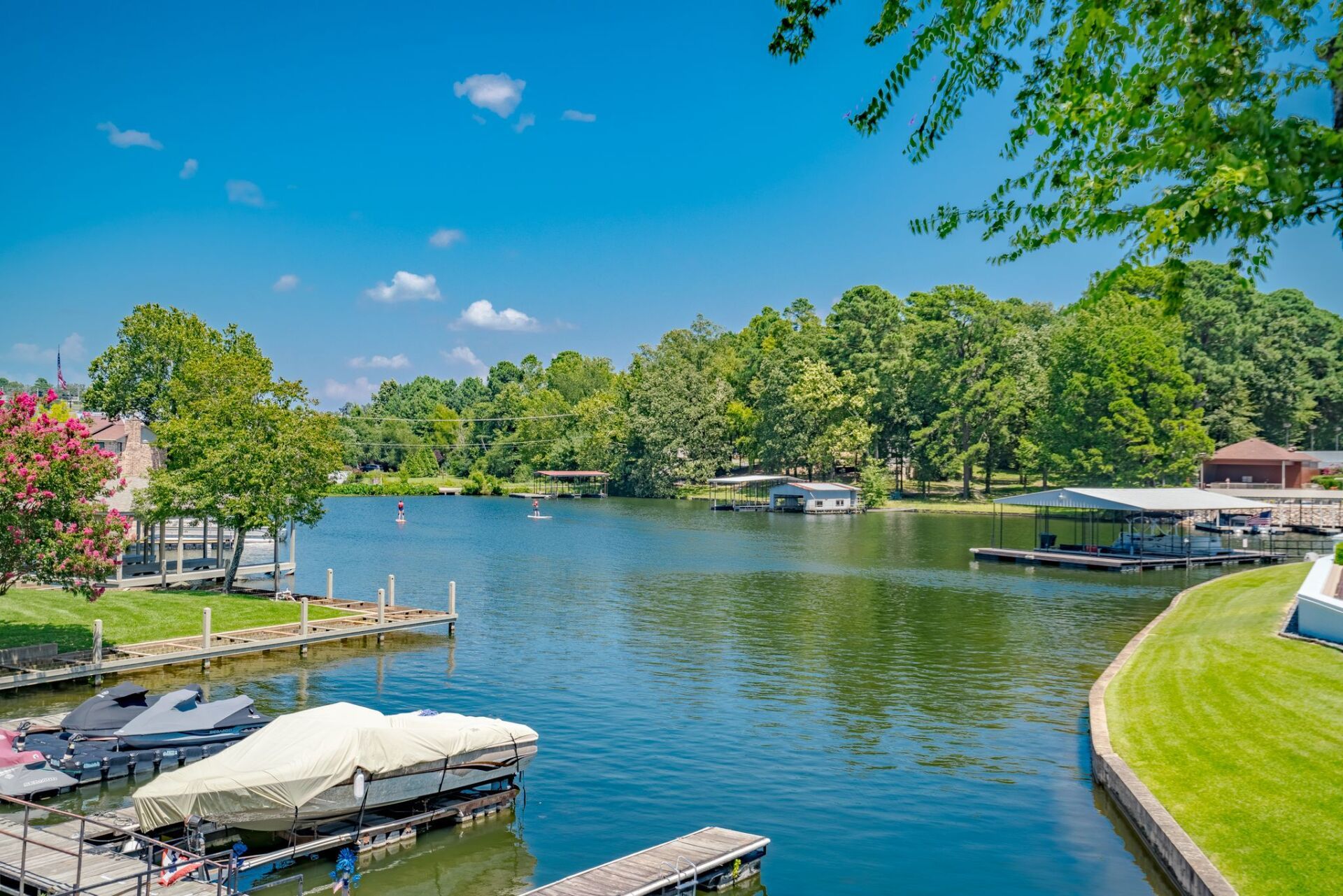A lake with boats docked at a dock on a sunny day.