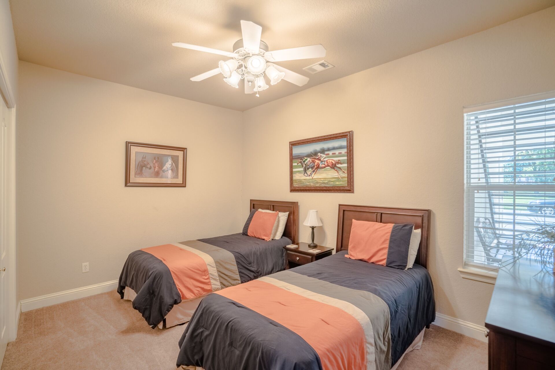 A bedroom with two twin beds and a ceiling fan.