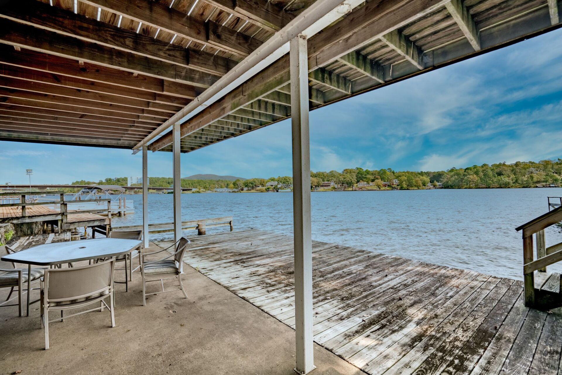 A patio with a table and chairs overlooking a lake