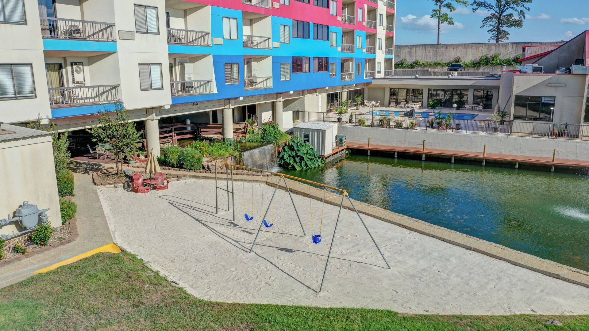 An aerial view of a volleyball court in front of a building next to a body of water.