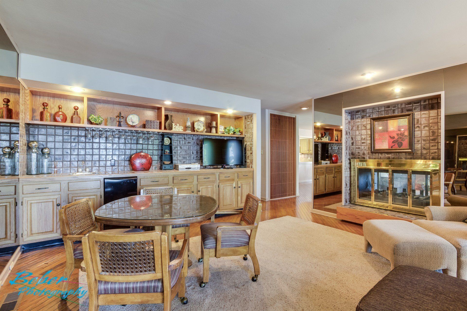 A living room with a table and chairs and a fireplace.