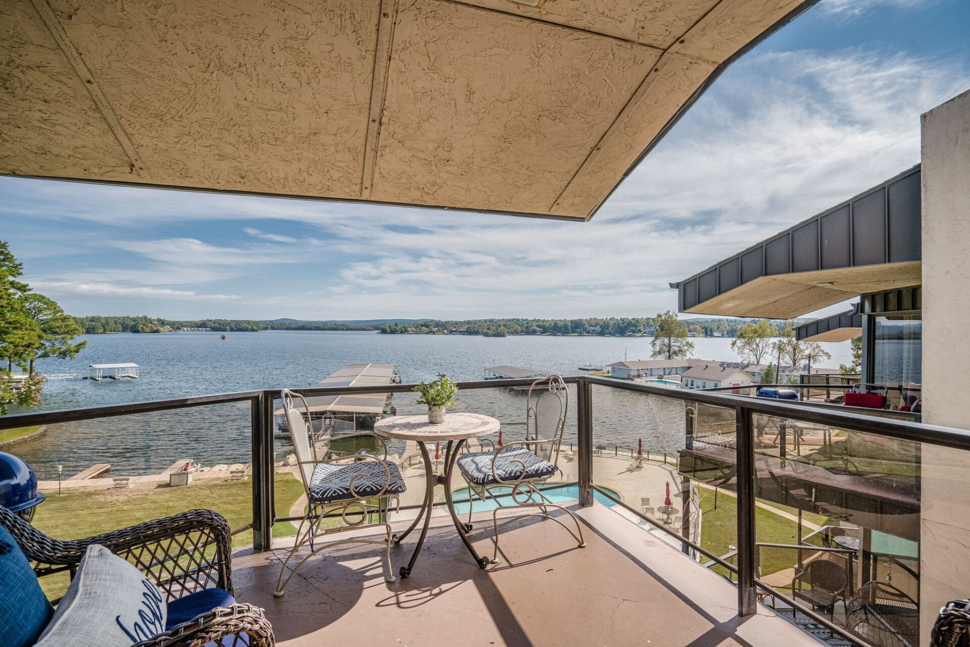 A balcony overlooking a lake with a table and chairs
