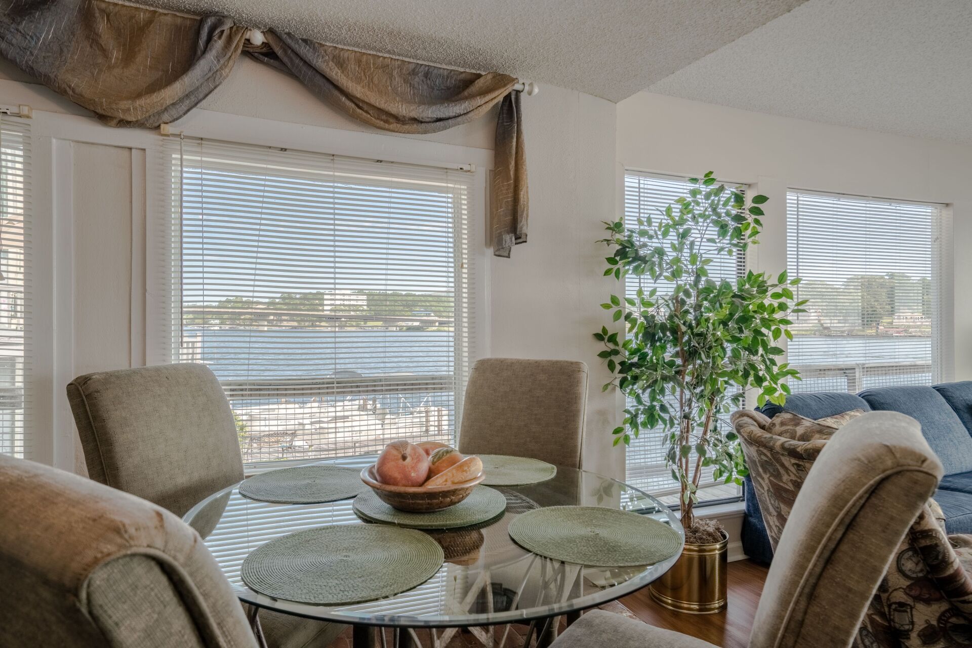 A living room with a dining table and chairs and a large window