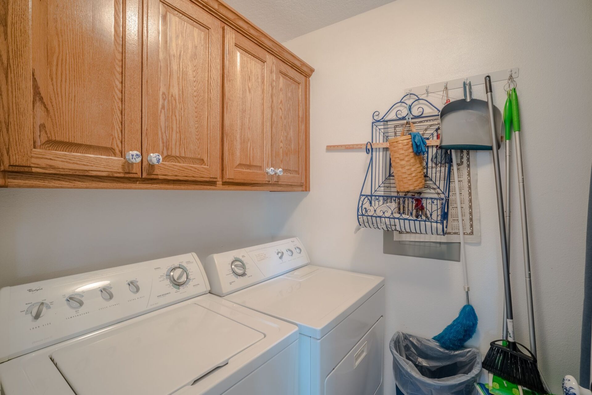 A laundry room with a washer and dryer and wooden cabinets.