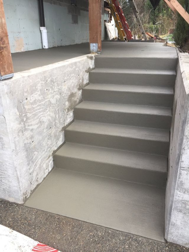 A set of concrete stairs leading up to a concrete wall.