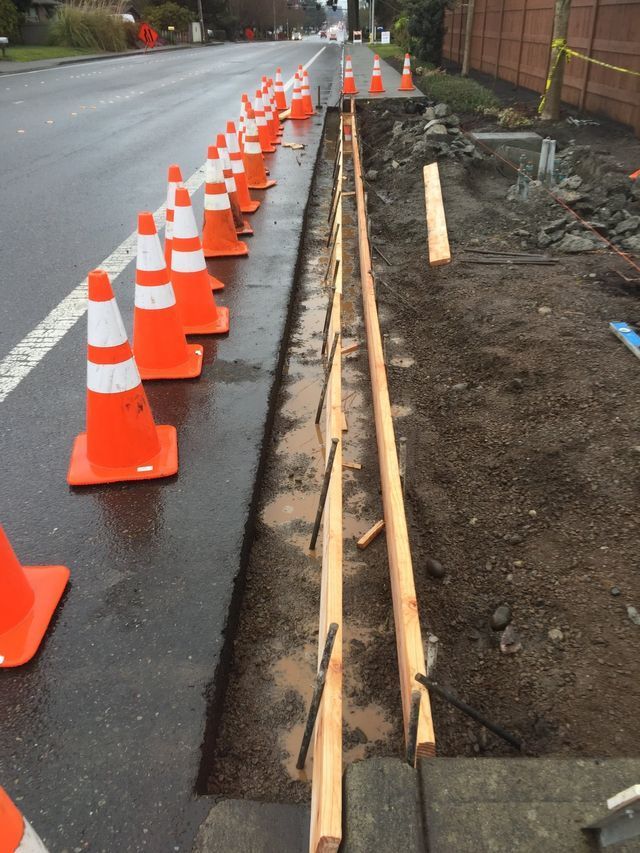 A row of orange and white traffic cones on the side of a road