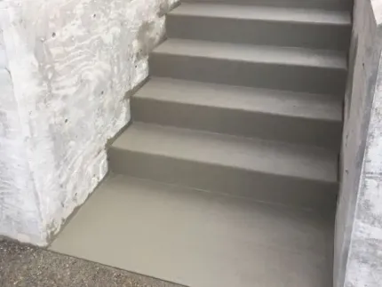 A set of concrete stairs leading up to a concrete wall.