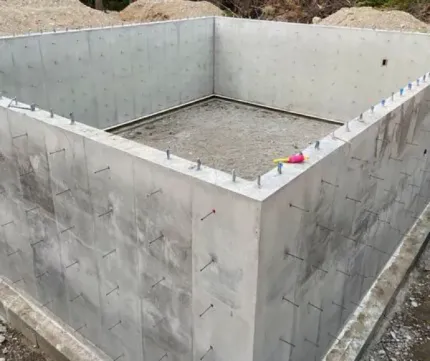 A large concrete foundation for a house is being built.