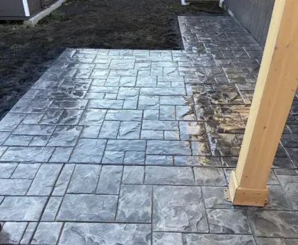 A concrete walkway with a wooden post in the middle of it.