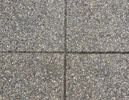 A close up of a gray tile floor with a cross in the middle.