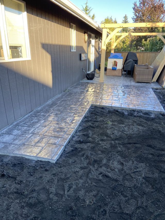A patio is being built in the backyard of a house.