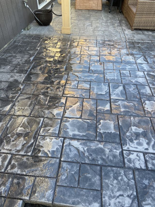 A dirty concrete patio with a chair in the background.