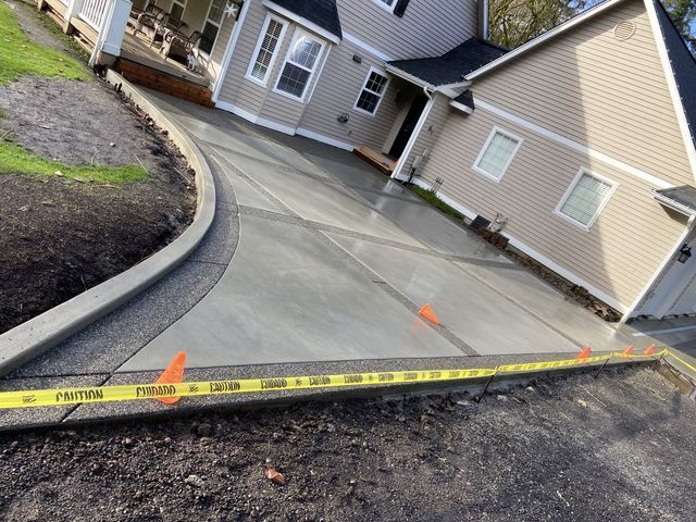 A concrete driveway is being built in front of a house