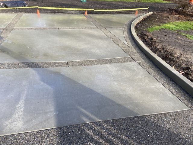 A concrete driveway with a curb on the side of it