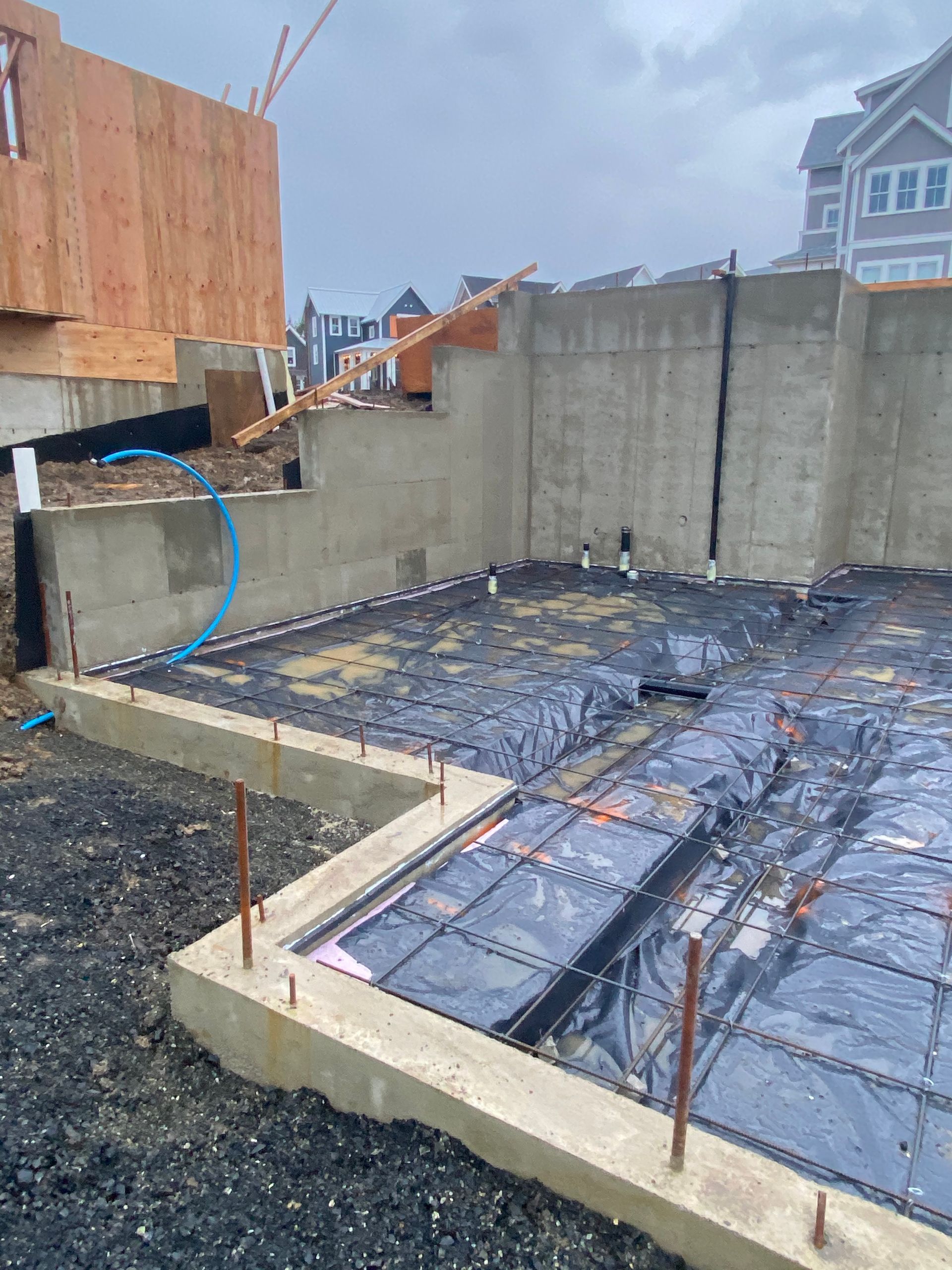 A basement under construction with a concrete floor and a concrete wall.