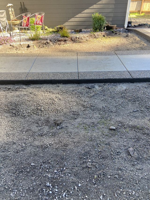 A concrete sidewalk is being built in front of a house.