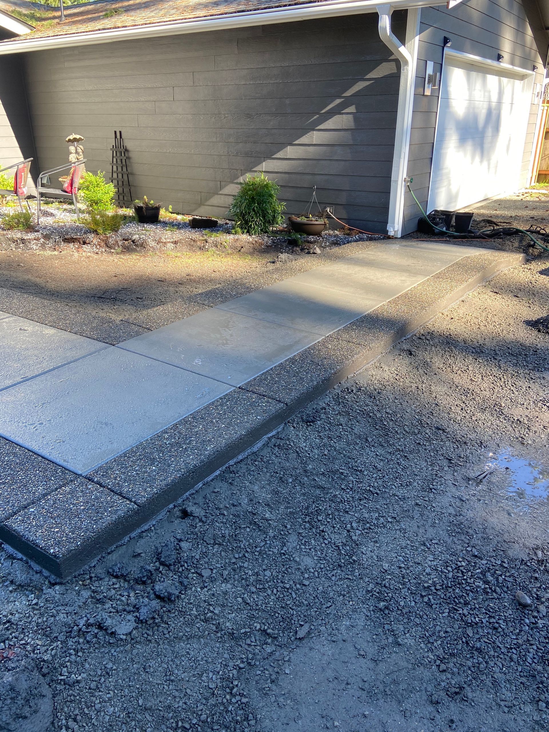 A concrete walkway is being built in front of a house.