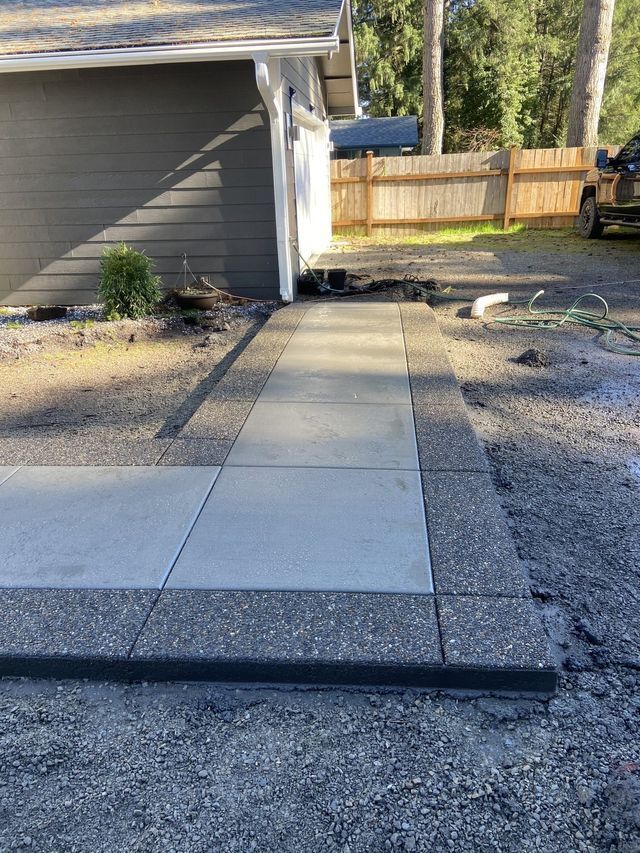 A concrete walkway is being built in front of a house.