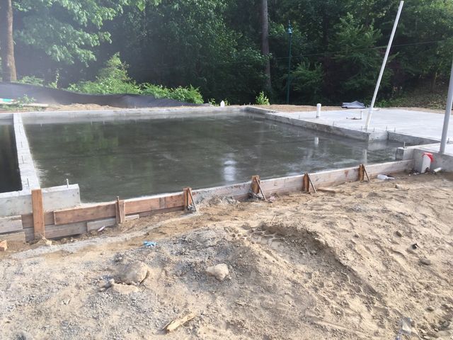 A large concrete slab is being built in the dirt.