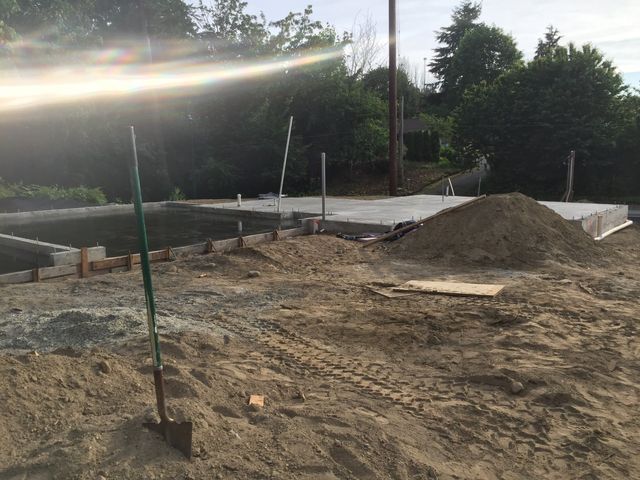 A shovel is sitting in the middle of a pile of dirt.