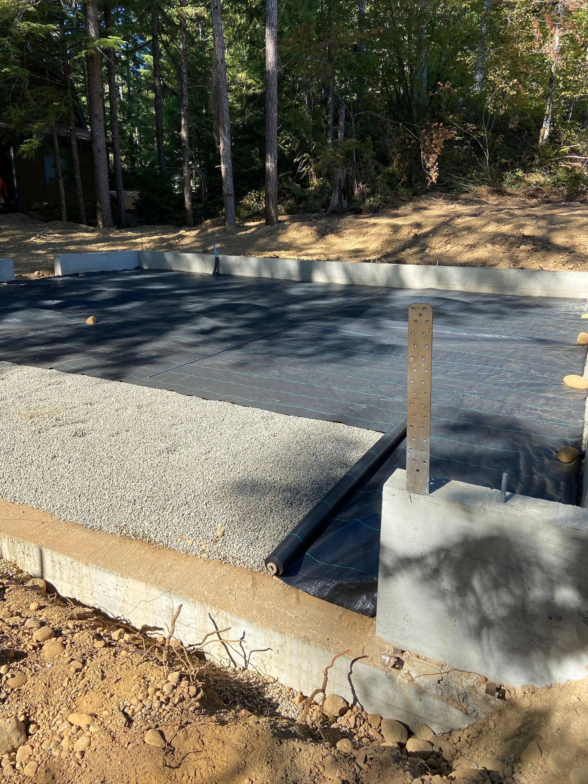 A concrete base for a house is being built in the woods.