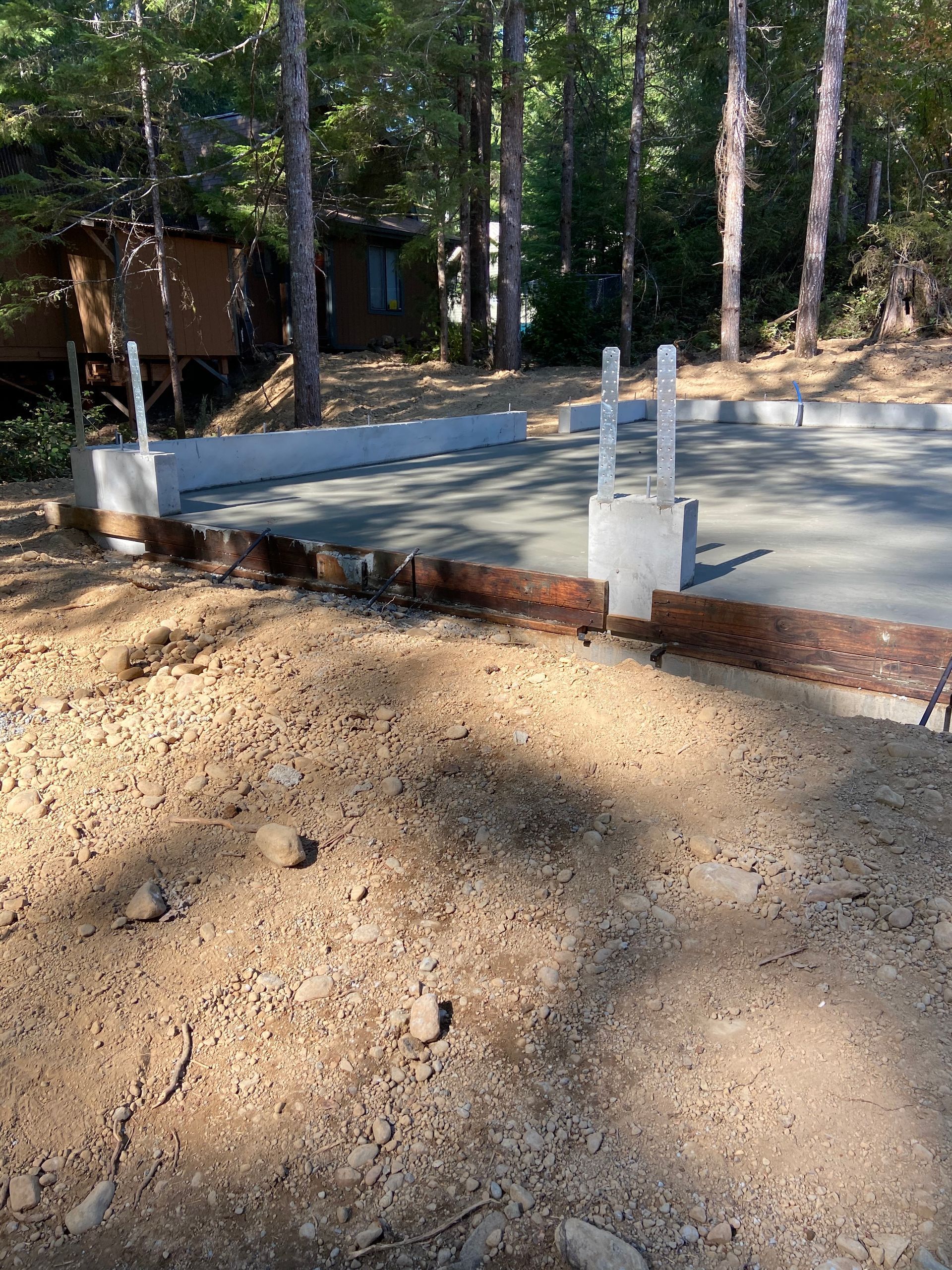 A concrete base is being built in the middle of a forest.