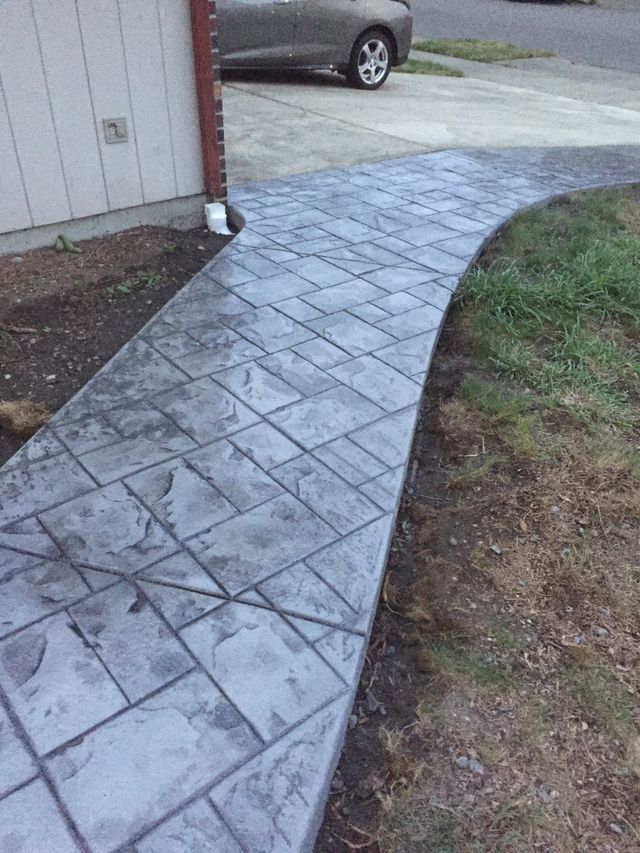 A concrete walkway with a car parked on the side of it.