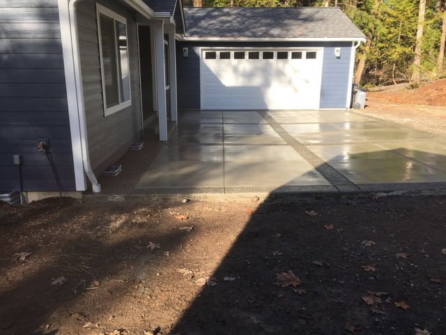 A blue house with a white garage door and a concrete driveway