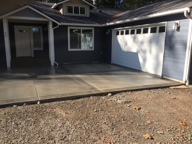 A house with a garage and a concrete driveway in front of it.