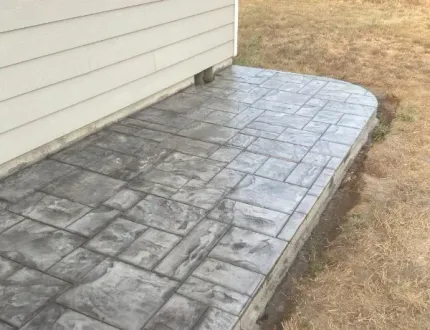 A concrete walkway is being built in front of a house.