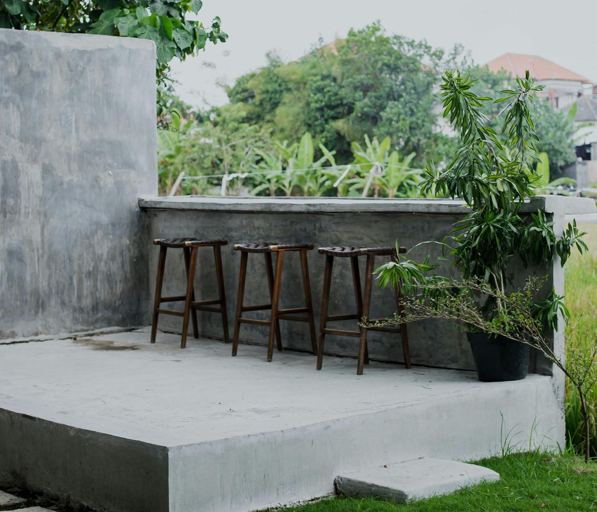 A concrete porch with a red door in front of a house.