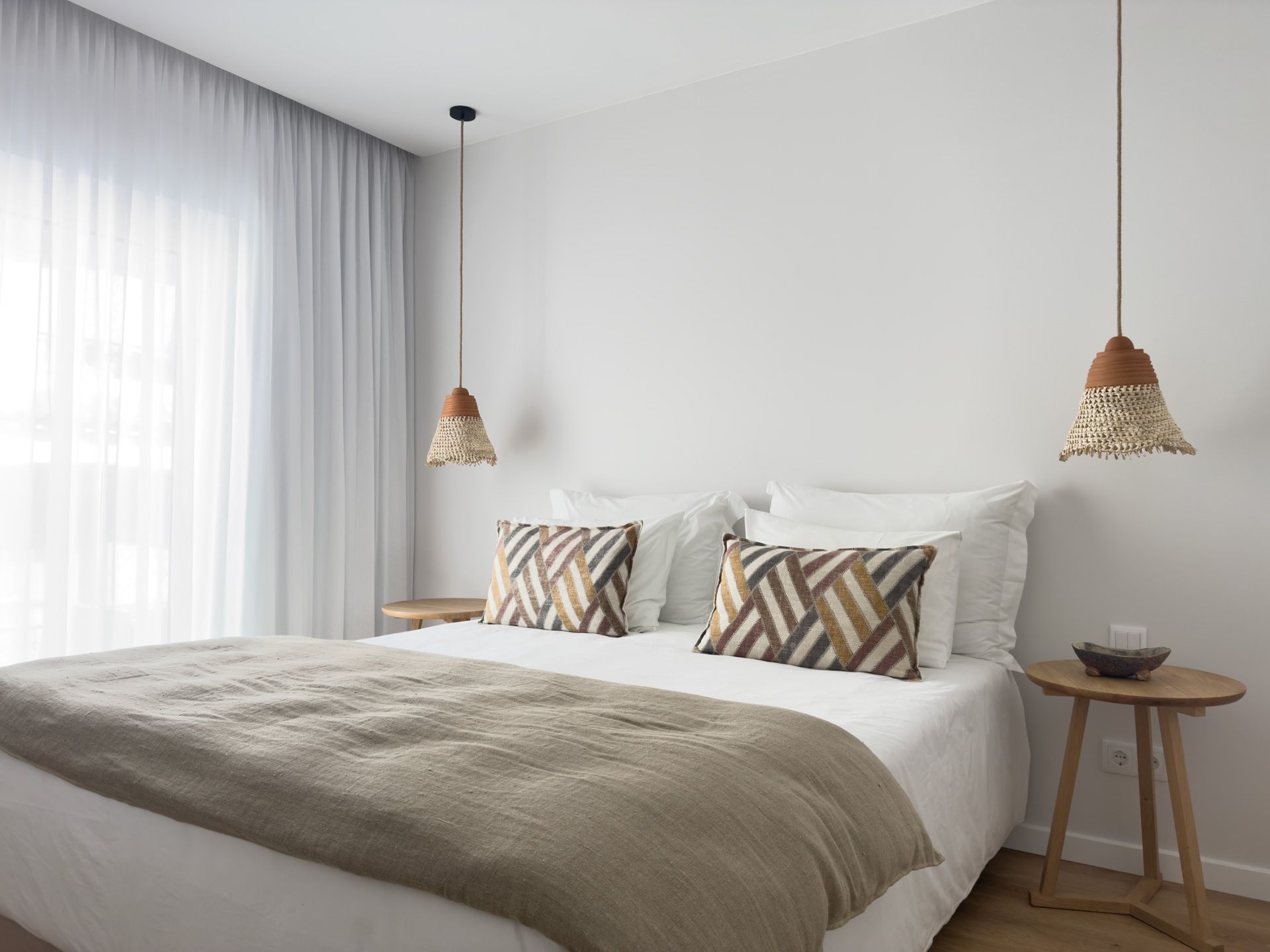 Uma sala de estar com sofá, mesa, televisão e varanda com vista para o oceano.