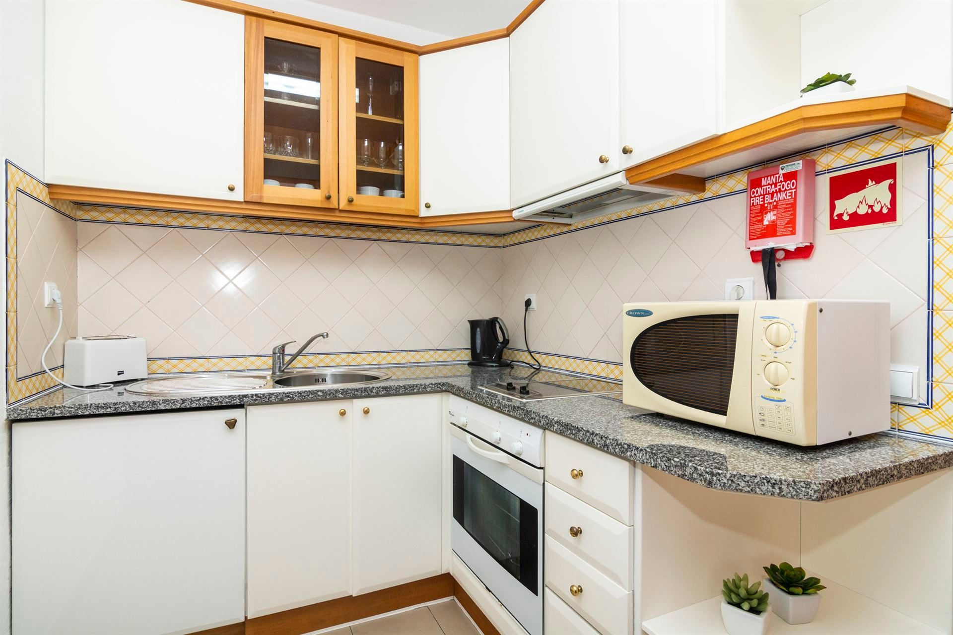 Uma cozinha com armários brancos e um forno de micro-ondas