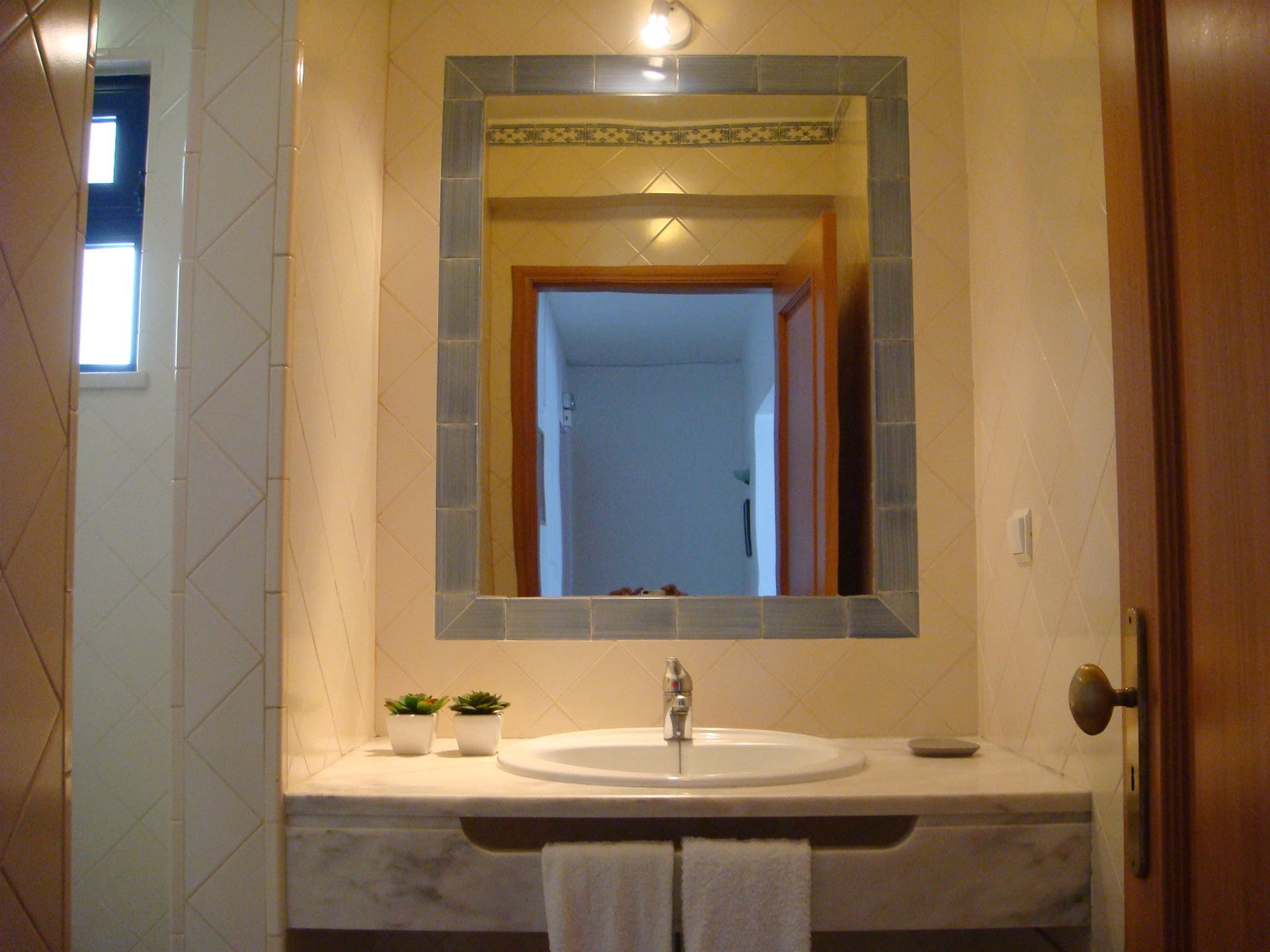 Um banheiro com uma pia e um espelho grande