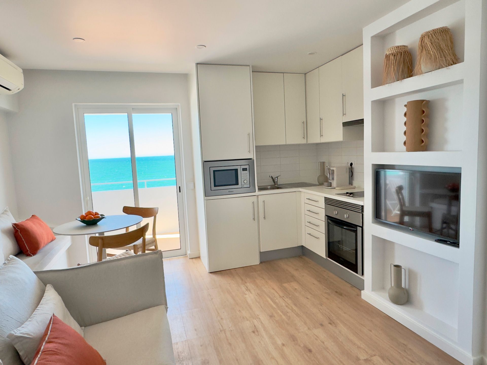 Uma sala de estar e cozinha com vista para o mar