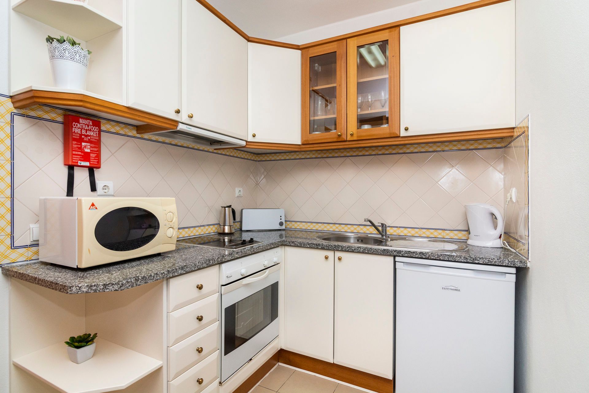 Uma cozinha com micro-ondas, forno, pia e lava-louças.