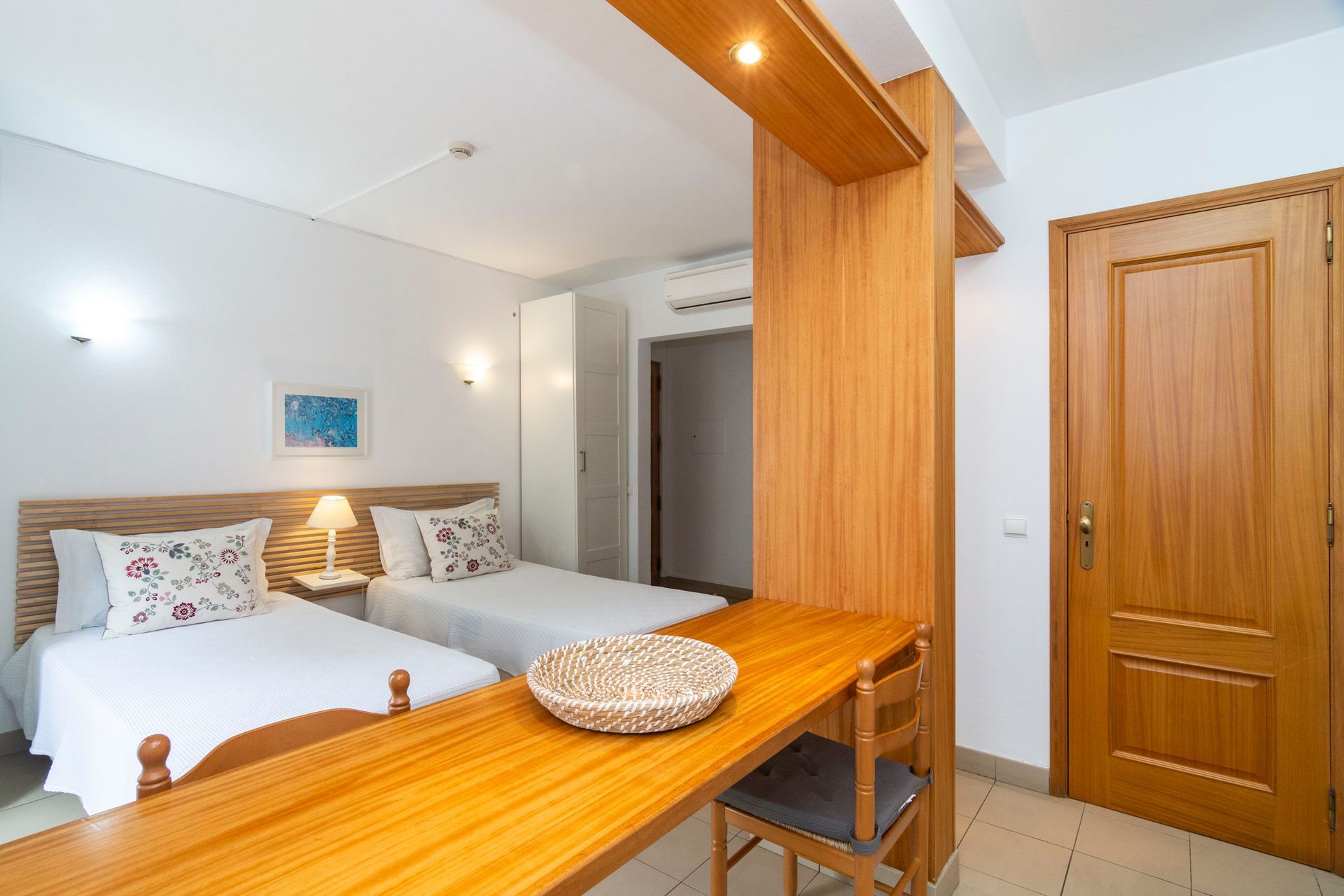 Um quarto com duas camas e uma porta de vidro deslizante