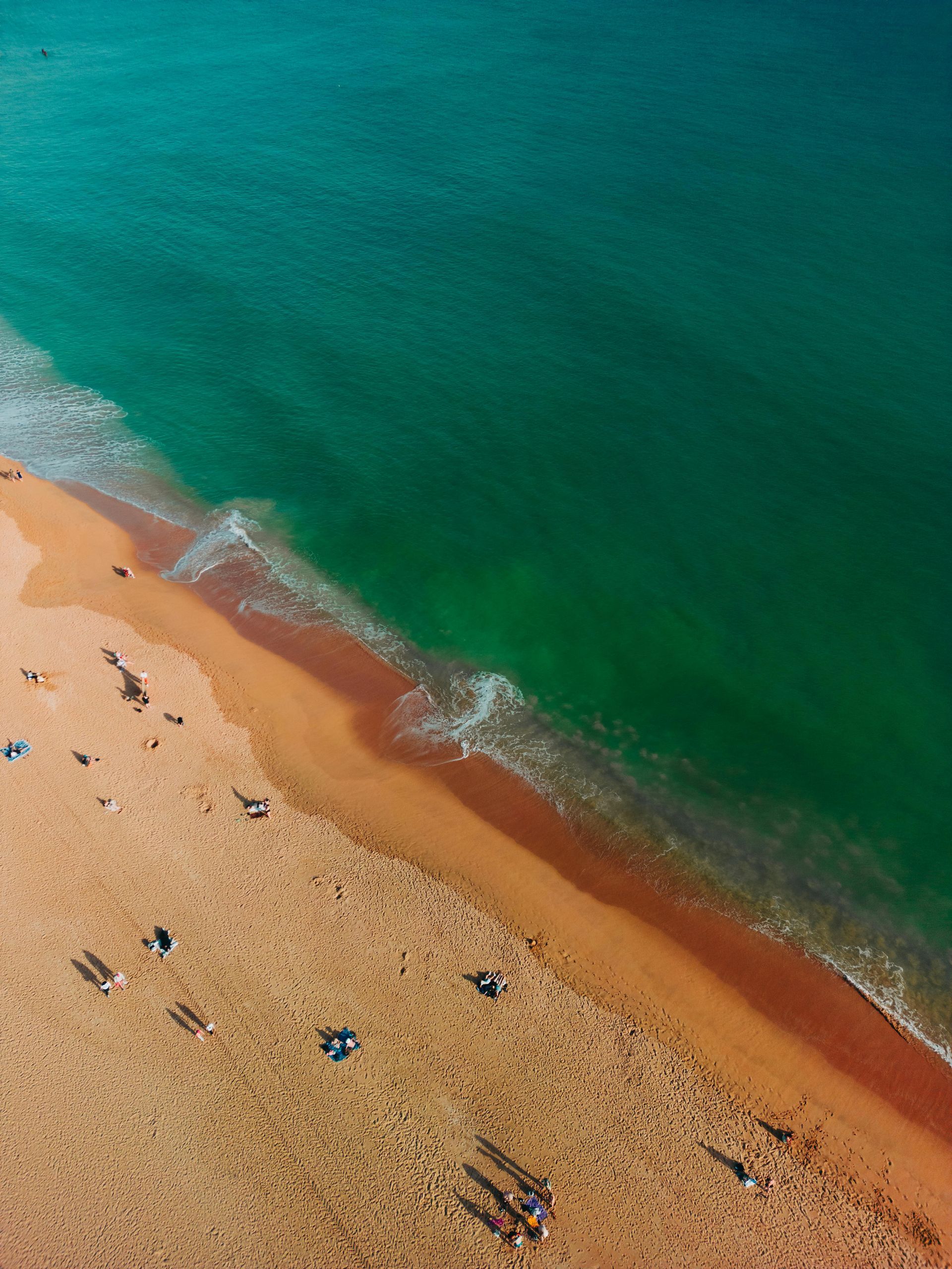 Uma vista aérea de uma praia de areia próxima ao oceano.