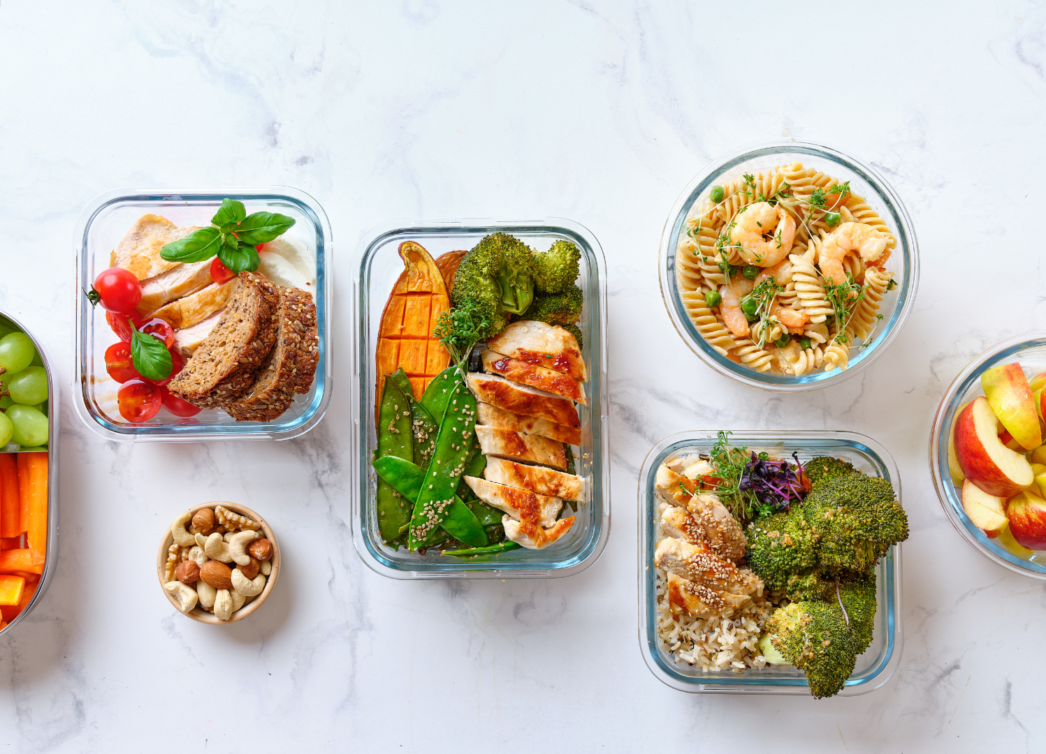A bunch of containers of food with broccoli and rice on a table.U