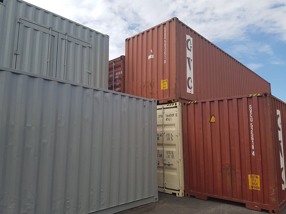 A Group Of Shipping Containers Are Stacked On Top Of Each Other — Oz Shipping Containers in Teralba, NSW