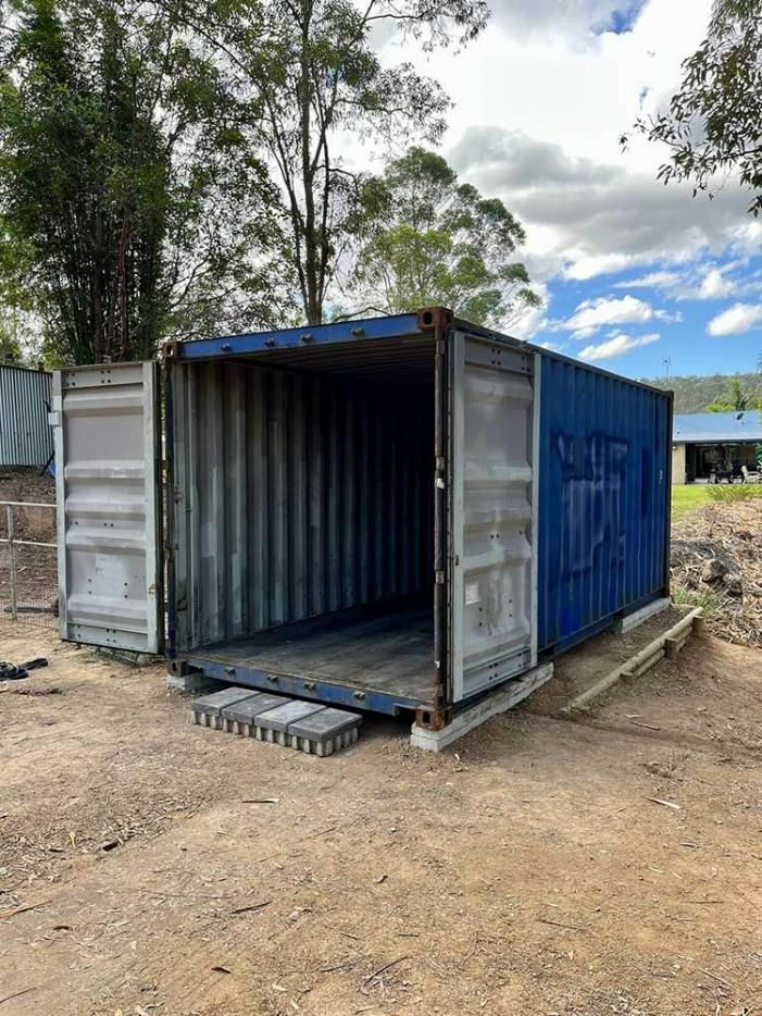 A Blue Shipping Container Is Sitting On Top Of A Dirt Field — Oz Shipping Containers in Port Hedland, WA