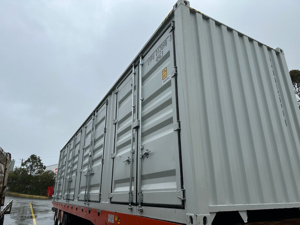A Large White Shipping Container Is Parked On The Side Of The Road — Oz Shipping Containers in Teralba, NSW