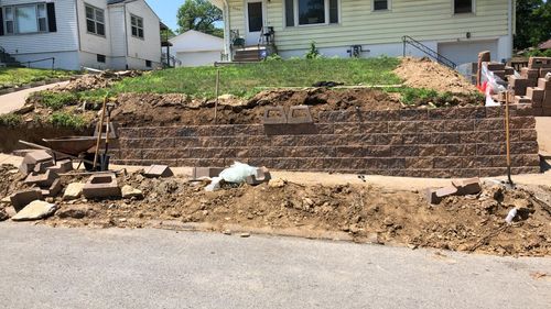 A brick wall is being built in front of a house.